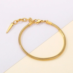 Detail of golden snake chain bracelet with adjustable tail and conical pendant
