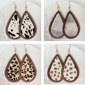 Detail view of four teardrop wood earrings with leopard and cow print faux fur inlays