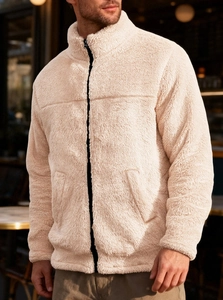 Close-up of beige Sherpa fleece jacket with black zipper and high collar stand detail