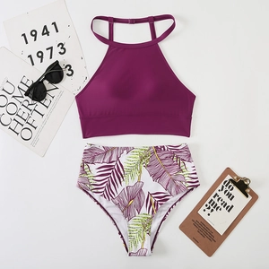 Flat lay of purple bikini top and high-waisted tropical palm leaf print bottoms