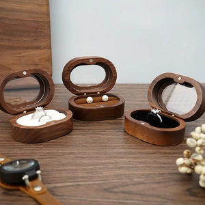 Detail of walnut wood jewelry box with transparent glass lid and velvet interior