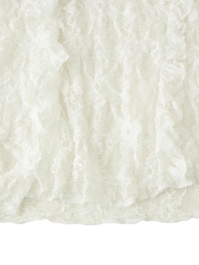 Close-up of intricate white lace pattern and hollowed knitting texture on the garment
