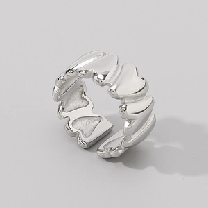 Detailed macro view of interconnected hollow heart shapes on a silver open ring band