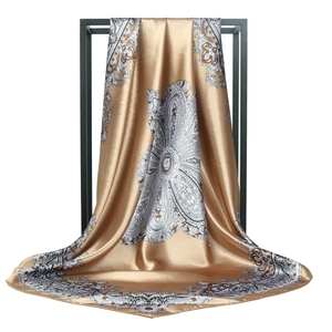 Elegant champagne gold satin square scarf with vintage paisley floral patterns on display