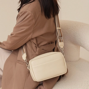 Minimalist beige pebble leather crossbody bag with stylish wide striped fabric shoulder strap