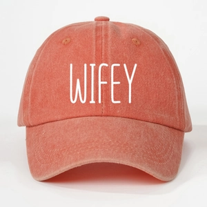 Detail of coral pink washed cotton baseball cap with white WIFEY embroidery lettering