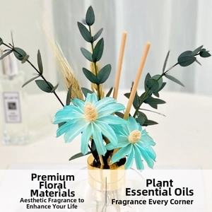 Close-up of reed diffuser with blue handmade flowers and green eucalyptus leaves