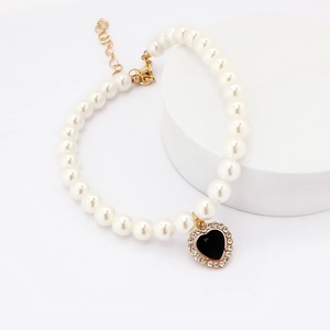 Detail shot of pearl pet necklace with heart-shaped black pendant and crystal accents
