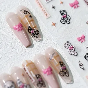 Macro detail of 5D teddy bear nail stickers with pink bows on nude nails