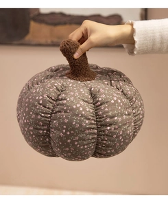 Detailed close-up of floral pumpkin plush pillow with brown leaf stem and soft texture