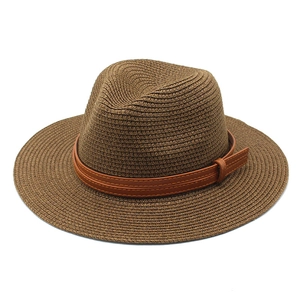 Détail d'un chapeau de paille marron foncé avec bande en cuir et surpiqûres