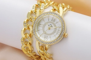 Macro shot of gold quartz watch with rhinestone bezel and chunky curb chain band