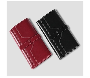 Detail view of red and black leather long wallets with contrast stitching and strap