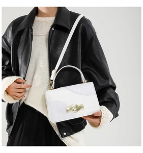 White square handbag with crocodile texture detail and gold wavy buckle shown on model