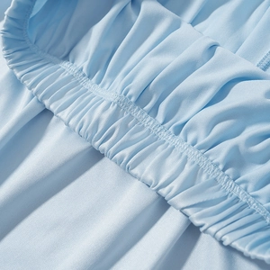Detail of light blue bohemian skirt showing elastic pleated waist and smooth fabric texture