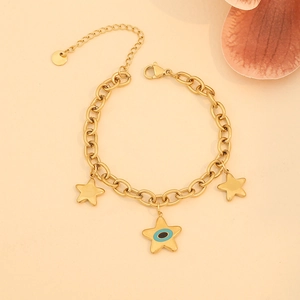Bracelet à chaîne dorée avec breloques étoiles et pendentif œil bleu sur fond beige