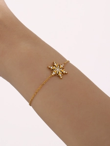 Detail of 18K gold-plated snowflake bracelet with pavé-set crystals worn on the wrist