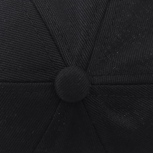 Gros plan du sommet d'une casquette de baseball en sergé de coton noir avec bouton