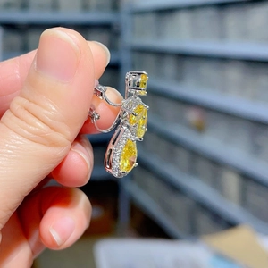 Detail view of pear-shaped yellow zircon earring with silver metal claw setting
