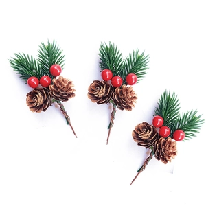 Detailed view of three festive pine needle branches with natural cones and red berries