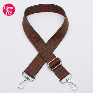 Detail of red and green houndstooth patterned bag strap with silver metal swivel hooks
