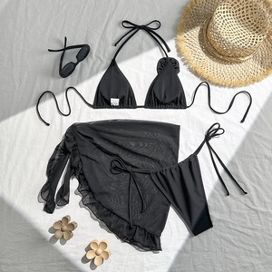 Macro shot of black bikini top with size S label and mesh ruffle skirt details