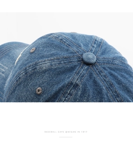 Macro shot of dark blue denim baseball cap showing premium cotton texture and stitching