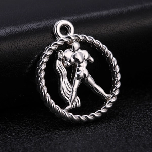 Macro view of a vintage silver-colored zodiac pendant with an embossed male silhouette