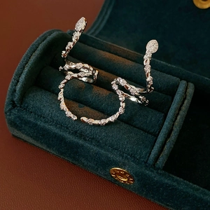 Silver snake earrings with zircon studs presented in a green velvet jewelry box