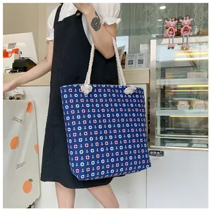 Detail of nautical canvas tote bag with anchor and lifebuoy prints and cotton rope handles