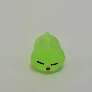 Close-up of green glowing bunny squeeze toy with matte texture and cute facial expression