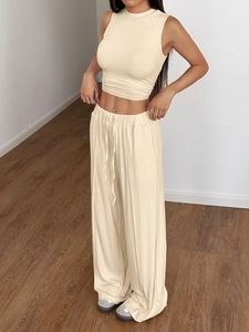 Dettaglio della maglia a coste beige sui pantaloni a vita alta e sul top corto abbinato
