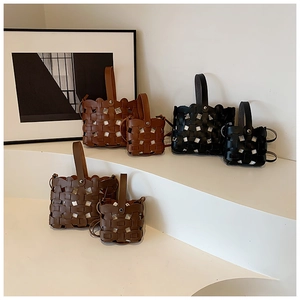 Detail of woven cutout leather handbag showing premium texture and H-pattern stitching