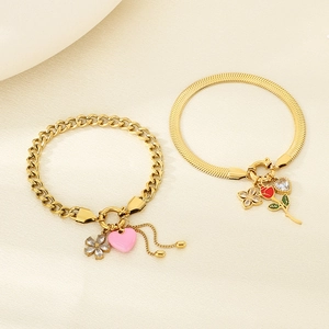 Detail of gold stainless steel bracelets with pink heart, rose, and zircon charms