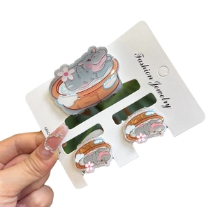 Cute acrylic hippo hair clip set with glitter and flower details on display card