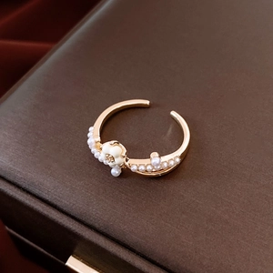 Detailed close-up of 14K gold plated ring with white enamel flower and delicate pearls