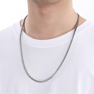 Close-up of silver stainless steel wheat chain necklace worn by a male model