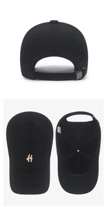 Detail view of cotton baseball cap with gold H letter logo and metal buckle strap