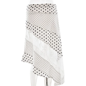 Detail view of white polka dot skirt featuring intricate lace panels and asymmetrical hem
