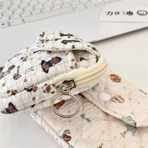 Close-up of quilted cotton bear pouches with floral patterns and zipper details