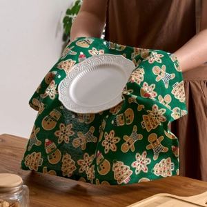 Festive green Christmas napkin featuring gingerbread man and snowman prints on linen fabric