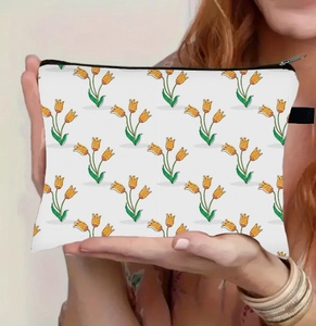 Detail der floralen Kosmetiktasche mit Tulpenmuster, die von Händen gehalten wird