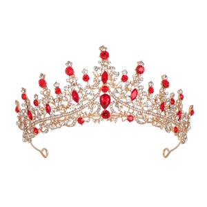 Macro shot of Baroque gold tiara featuring sparkling red rhinestones and hollow patterns