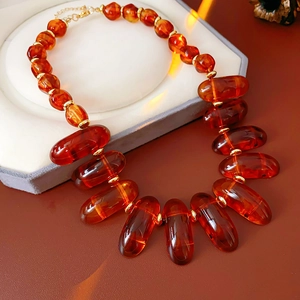 Detailed view of irregular amber resin beads with gold spacers on a chunky necklace