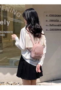 Close-up of pink mini backpack with classic monogram pattern and gold zipper detail