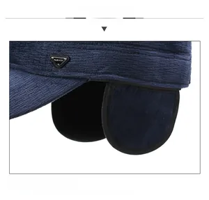 Close-up of winter flat cap showing navy corduroy texture and thick ear protection detail