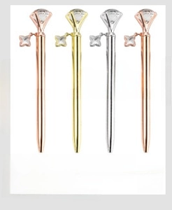 Detail of diamond topped metal pens in rose gold and silver with flower charms