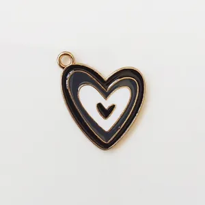Detail of a heart-shaped enamel pendant with black and white layers and gold metal edges