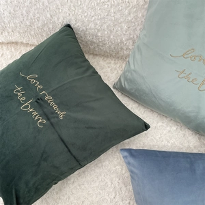 Close-up of golden embroidery on soft velvet cushions in Morandi color tones