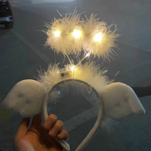 Close-up of a white feather angel headband featuring glowing LED lights and small wings